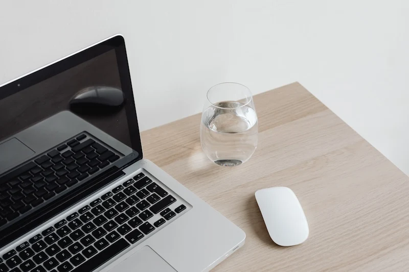 kaboompics laptop computer keyboard magic mouse glass of water 25540