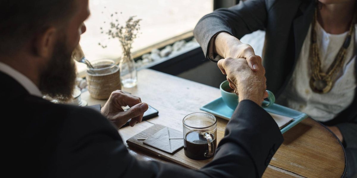 Business agreement handshake at coffee shop